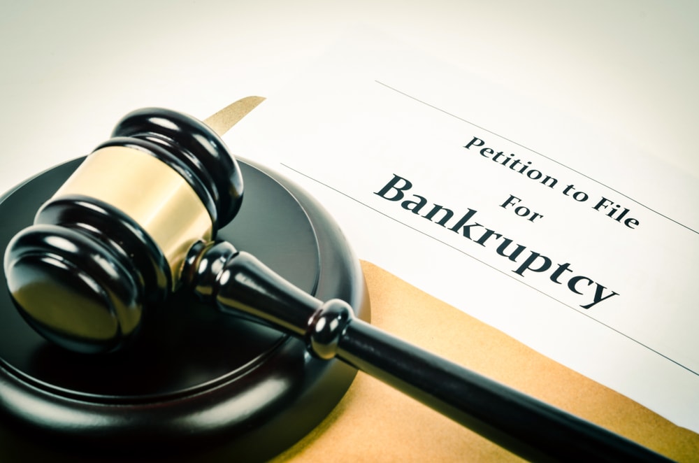 Consumer bankruptcy calculator, gavel and financial debt relief forms